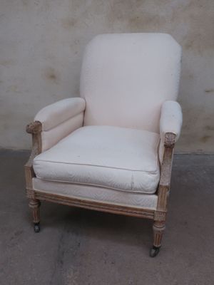 a white chair that is sitting in front of a wall