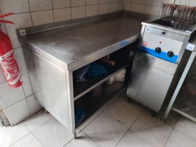 a small kitchen with a stainless steel counter and a fire extinguisher
