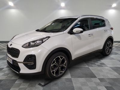 une voiture blanche garée dans une pièce au sol en damier