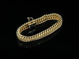 a gold bracelet on a black surface