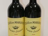 two bottles of red wine sitting next to each other on a table