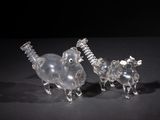 two clear glass figurines of animals on a black surface