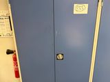 two blue lockers in a room with a fire extinguisor