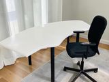 a white desk with a black chair in front of a window