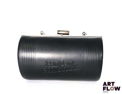 La pochette en cuir noir est posée sur une surface blanche