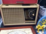 an old radio sitting on a table next to a clock