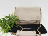a white and black purse with a plant on top of it