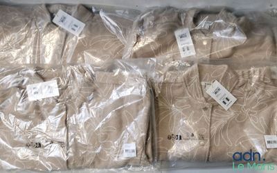 three men ' s shirts are wrapped in plastic bags on a table
