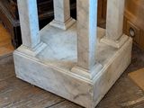 a white marble pedestal with a clock on top of it