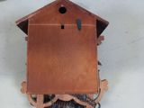 a wooden cuckoo clock with a chain hanging from it ' s side