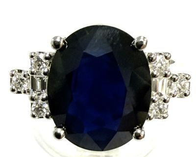 a close up of a blue sapphire and diamond ring on a white background