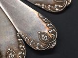 two silver spoons that are sitting on a table