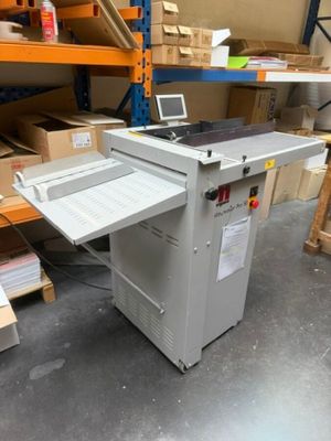 La machine est posée par terre dans l'entrepôt.