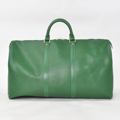a green duffel bag sitting on top of a white surface