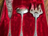 three silver spoons and a fork in a red box