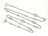 trois bracelets à maillons argentés sur fond blanc
