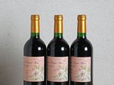 trois bouteilles de vin posées sur une table en bois