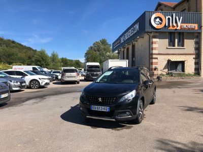 the black car is parked in front of the building in the parking lot