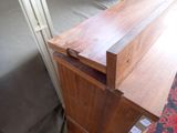 a wooden dresser with a drawer on top of it