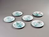 six small plates with flowers on them are sitting on a table