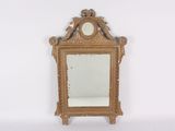 a gold mirror with a clock on the top of it