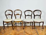 four chairs are lined up in a row on a wooden floor