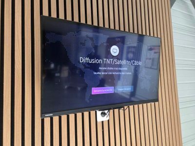 un téléviseur à écran plat fixé au mur d'une pièce