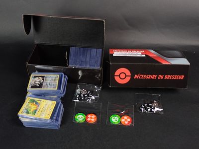 une boîte contenant des cartes, des dés et d'autres objets, posée sur une table