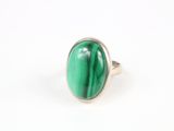 Gros plan sur une bague ornée d'une pierre verte
