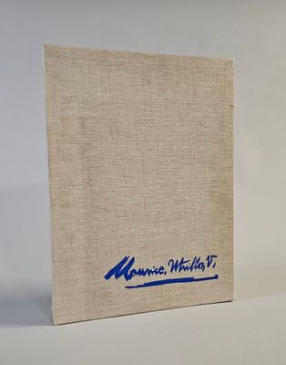 an old book with a blue logo on it sitting on a white surface