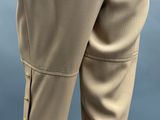 beige pants with gold buttons on the side of the pants