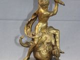 brass figurine of a woman holding a sword and sitting on top of an elephant