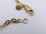 two pieces of gold chain with charms on them on a white surface