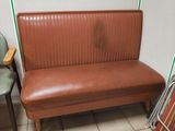a brown leather bench in the corner of a room