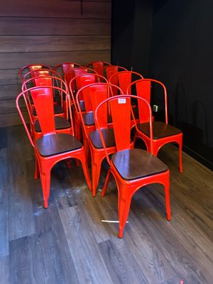 Plusieurs chaises rouges sont alignées en rangée dans une pièce