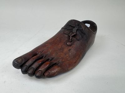 un vieux sabot en bois orné d'une fleur sur la pointe