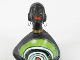 a black and green vase with a woman ' s face on it
