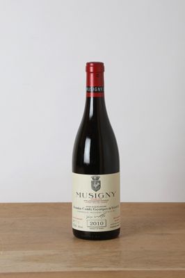 a bottle of red wine sitting on top of a wooden table