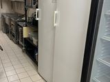 un réfrigérateur blanc dans une cuisine, à côté d'un plan de travail