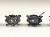 trois petits vases en argent contenant des cuillères