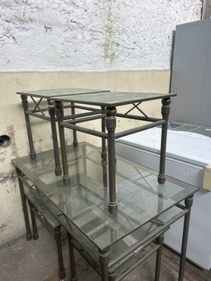 trois tables avec des plateaux en verre et un réfrigérateur à l'arrière-plan