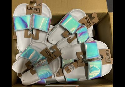 une boîte contenant plusieurs paires de sandales blanches