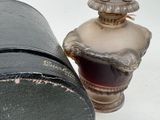 a small vase with a hat on it next to a box