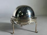 an antique silver plate with a domed lid on a stand