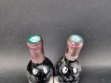 two bottles of wine sitting next to each other on a table