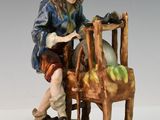 une image représentant une figurine d'un homme assis sur une chaise