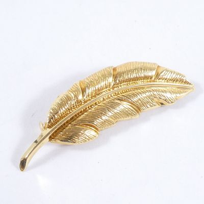 une broche en feuille d'or sur un fond blanc