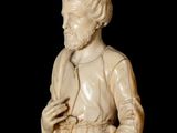 statue of a man with a beard and a robe holding a book