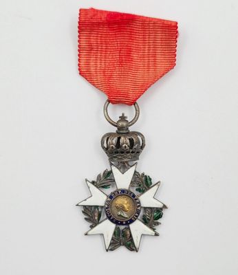 un gros plan d'une médaille ornée d'un ruban rouge sur fond blanc