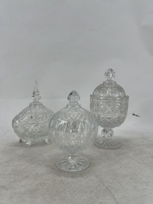 three clear glass jars with lids sitting on a white surface